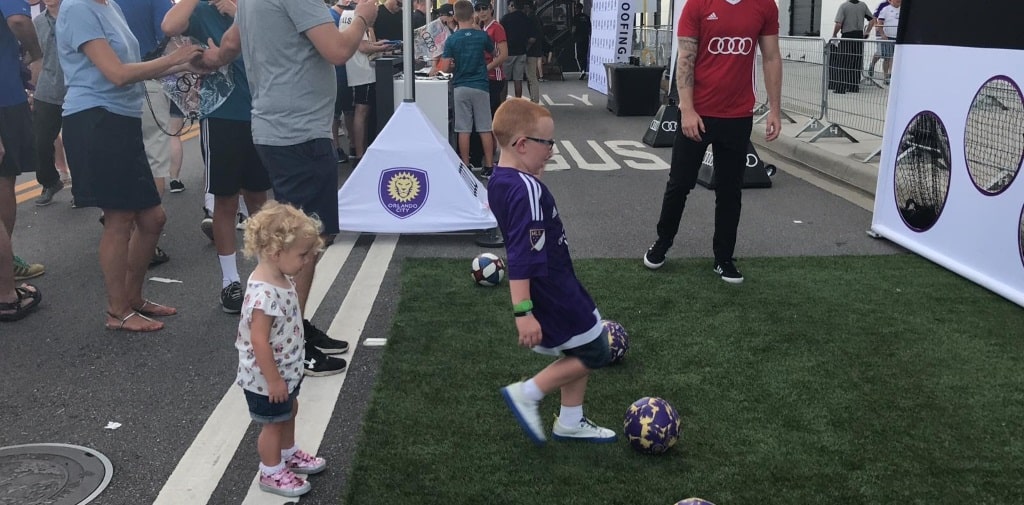 Alex and Izzy playing football outside the stadium