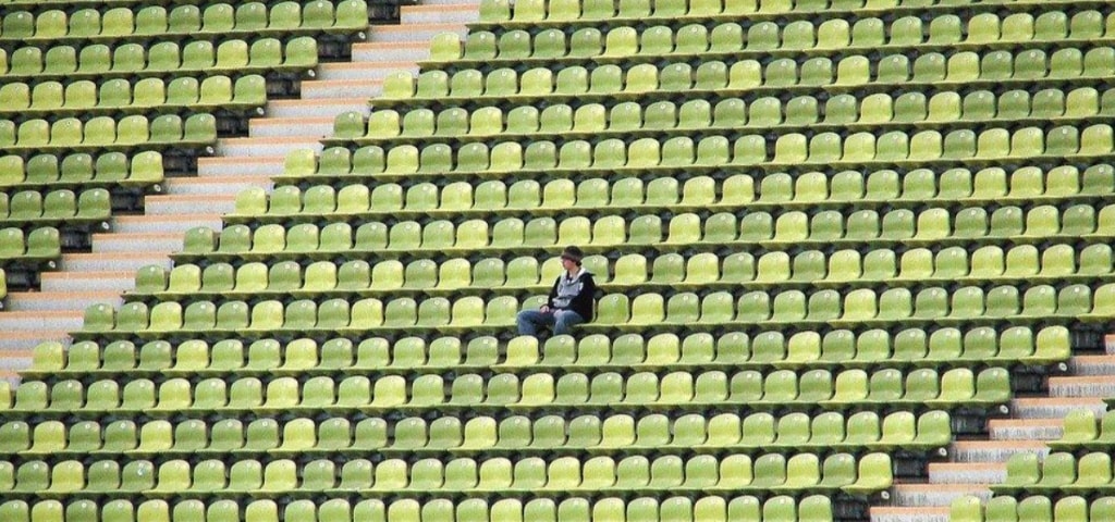 A lonely fan sits in the stands